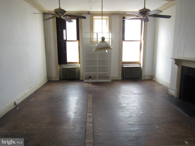 unfurnished living room with baseboards, a fireplace, wood finished floors, and radiator