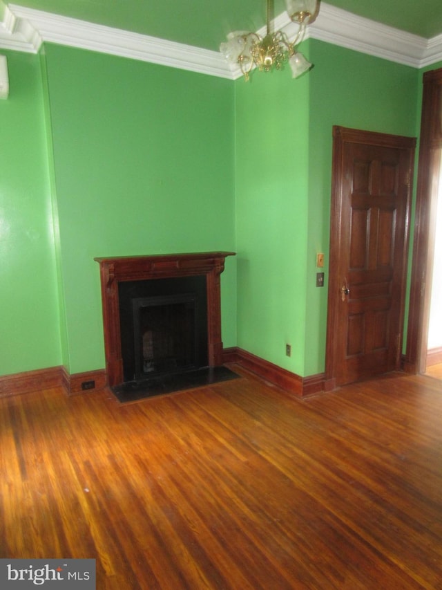 unfurnished living room featuring a fireplace with flush hearth, baseboards, wood finished floors, and crown molding