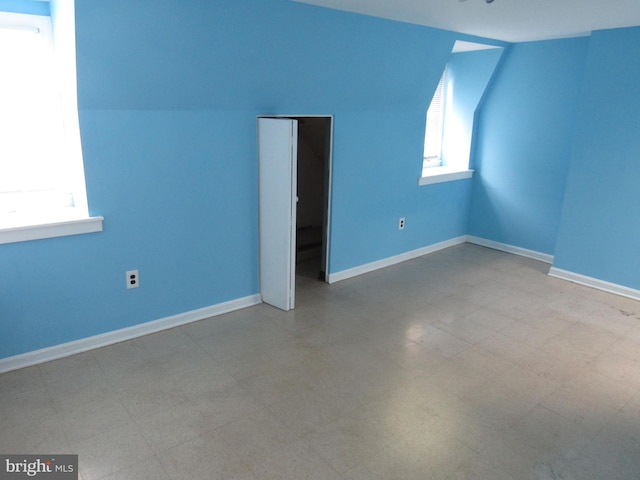 additional living space featuring lofted ceiling and baseboards