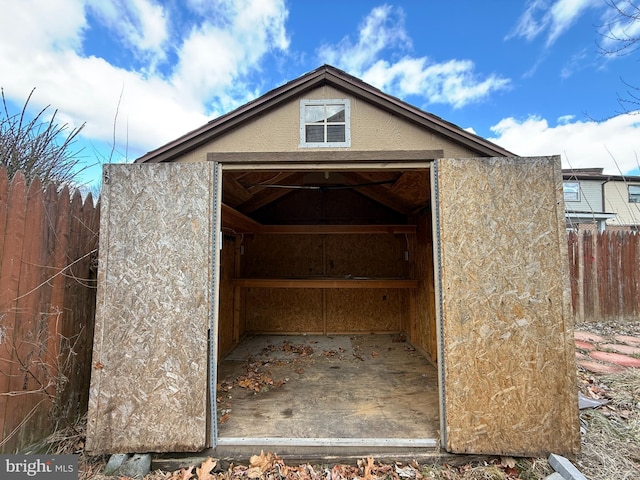 view of shed with a garage and fence