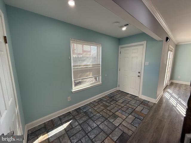 entryway featuring brick floor, crown molding, recessed lighting, visible vents, and baseboards