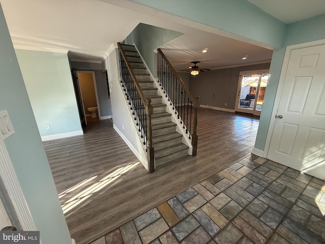 stairs featuring ceiling fan, baseboards, crown molding, and wood finished floors