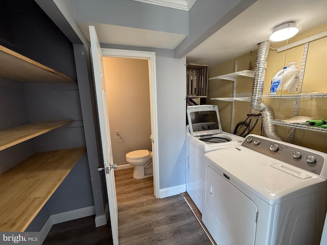 laundry area featuring laundry area, baseboards, washer and clothes dryer, and wood finished floors