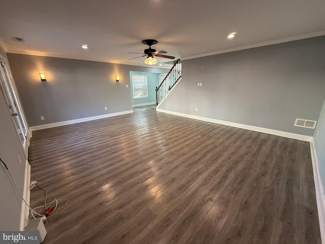 unfurnished living room with crown molding, visible vents, dark wood-type flooring, baseboards, and stairs