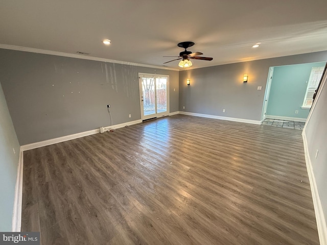 spare room featuring baseboards, wood finished floors, a ceiling fan, and crown molding