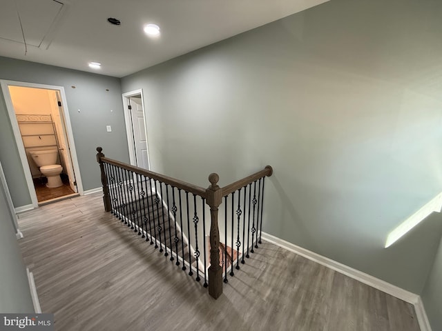 stairs featuring wood finished floors, attic access, and baseboards