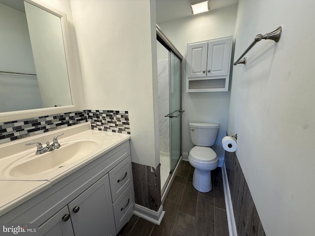 bathroom featuring toilet, tasteful backsplash, wood tiled floor, and a shower stall