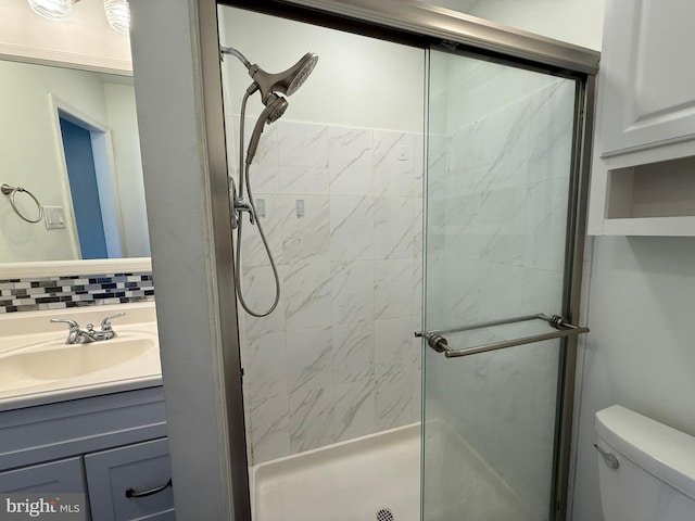 full bath with decorative backsplash, a shower stall, toilet, and vanity