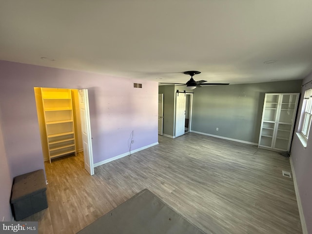 unfurnished bedroom featuring wood finished floors, visible vents, and baseboards