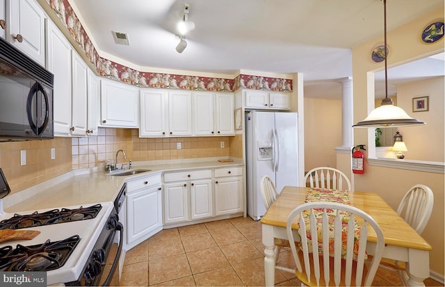 kitchen with white appliances, light countertops, a sink, and white cabinetry