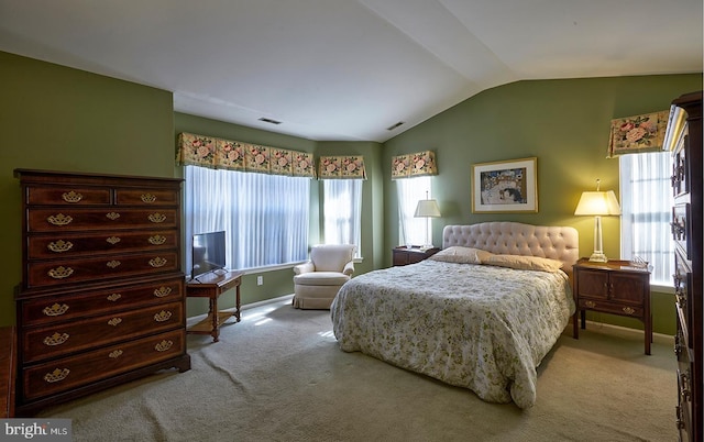 bedroom featuring visible vents, vaulted ceiling, and light carpet