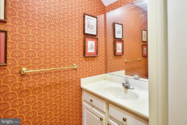 bathroom with wallpapered walls and vanity