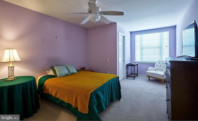 bedroom with a ceiling fan and light colored carpet