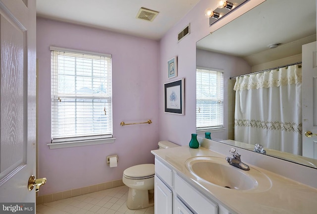 bathroom with tile patterned flooring, toilet, vanity, visible vents, and baseboards