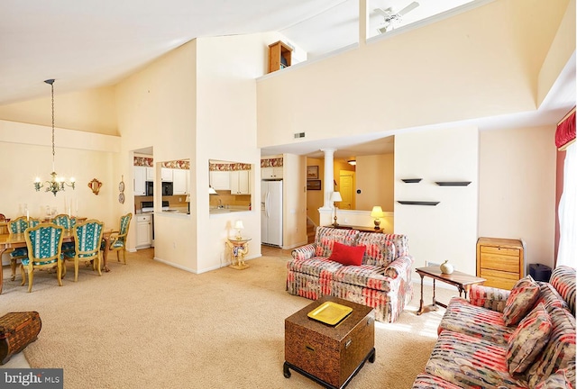 living room with decorative columns, visible vents, an inviting chandelier, carpet flooring, and high vaulted ceiling