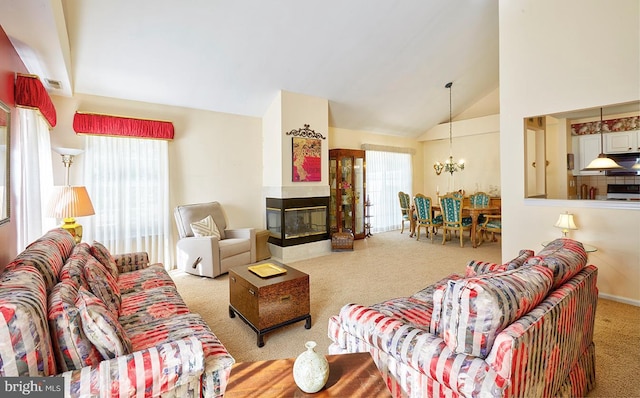 carpeted living area with high vaulted ceiling, a chandelier, a wealth of natural light, and a multi sided fireplace