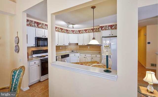 kitchen with white gas range oven, visible vents, dishwashing machine, freestanding refrigerator, and black microwave