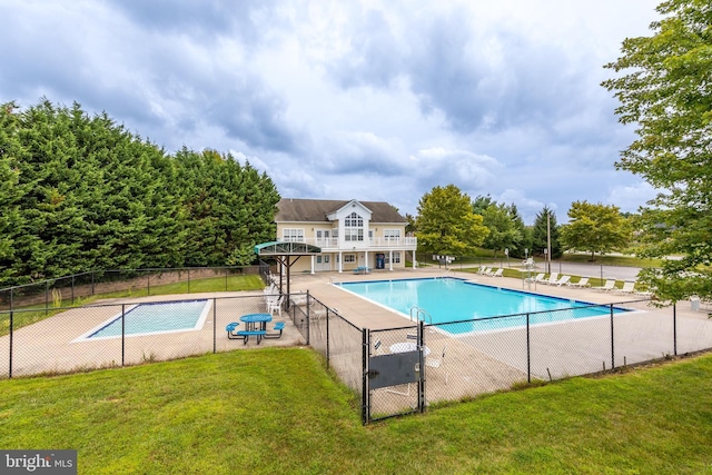 community pool featuring a lawn and fence