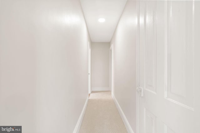 hall featuring light carpet and baseboards