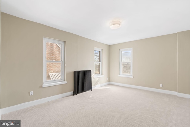 unfurnished room with carpet floors, radiator heating unit, and baseboards