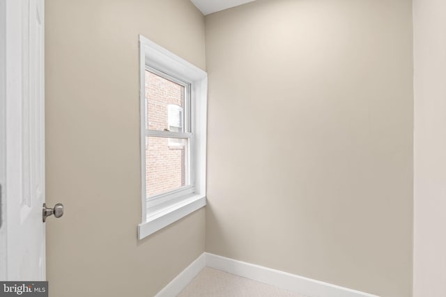 unfurnished room featuring a wealth of natural light and baseboards