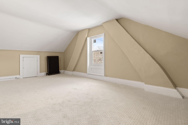 bonus room with lofted ceiling, radiator heating unit, carpet, and baseboards