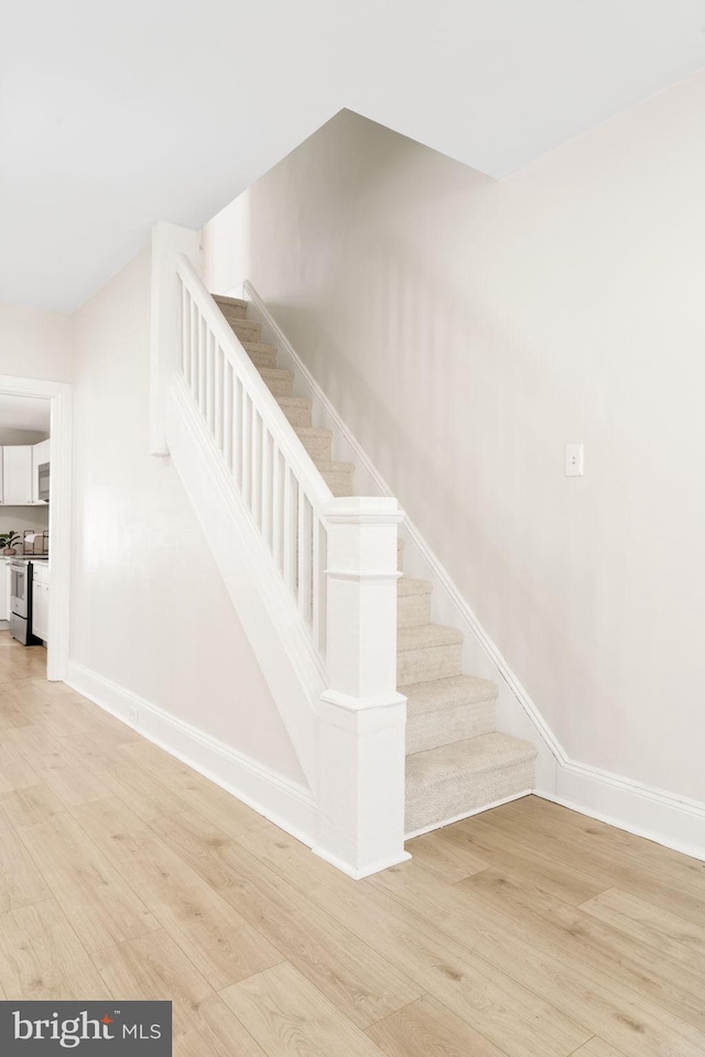 stairs with baseboards and wood finished floors