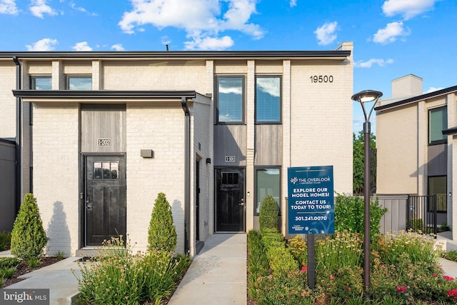 entrance to property featuring brick siding and fence