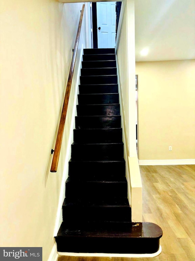 stairs with baseboards and wood finished floors