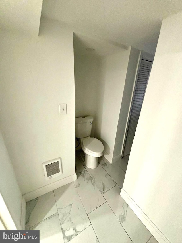 bathroom with marble finish floor, visible vents, toilet, and baseboards