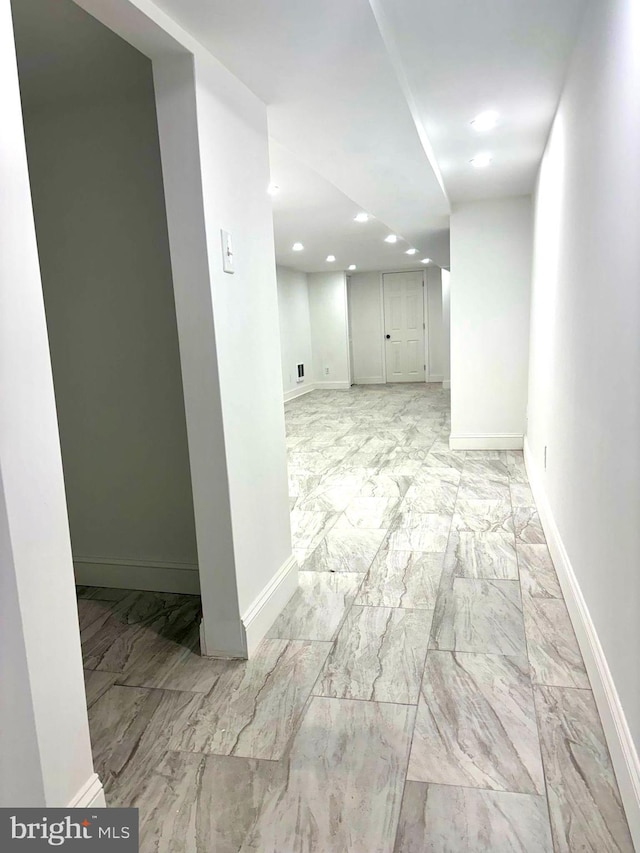 basement with marble finish floor, recessed lighting, and baseboards