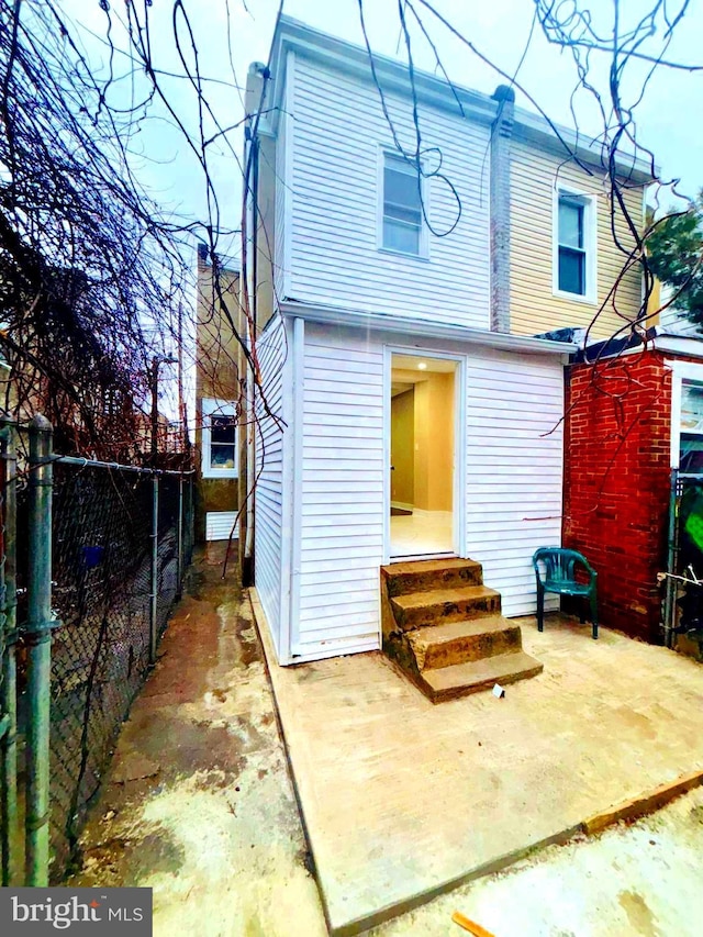 back of property featuring entry steps and fence