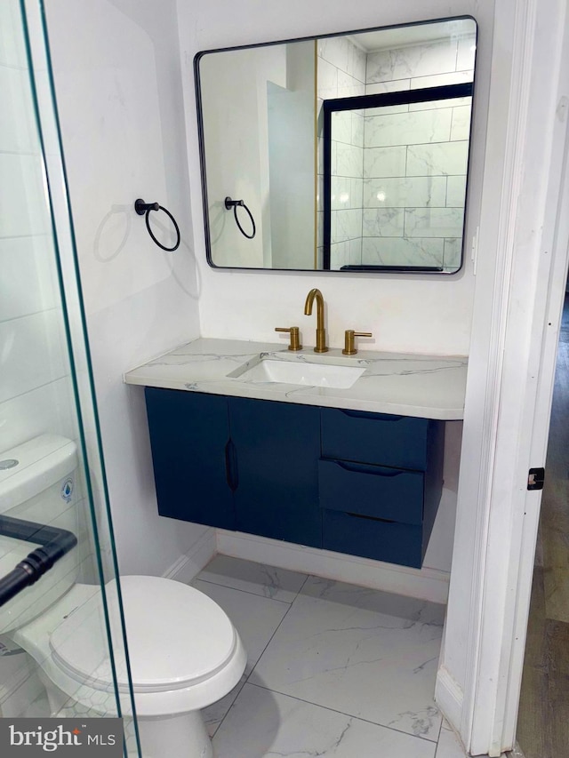 bathroom featuring toilet, marble finish floor, and vanity