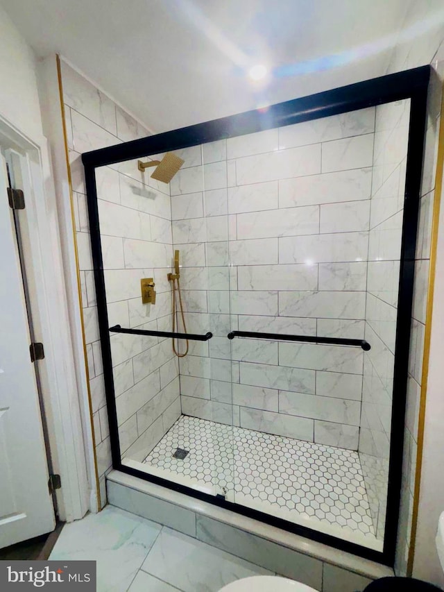 full bath featuring marble finish floor and a stall shower