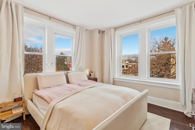 bedroom featuring multiple windows, dark wood finished floors, visible vents, and baseboards