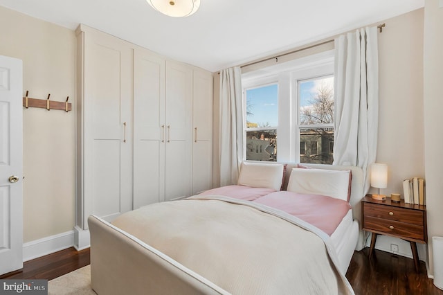 bedroom with dark wood-style floors and baseboards