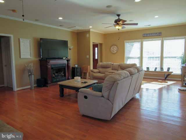 living area featuring recessed lighting, light wood-style floors, ceiling fan, and crown molding