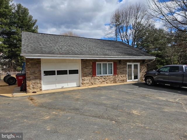 view of front of house with an attached garage, driveway, and roof with shingles