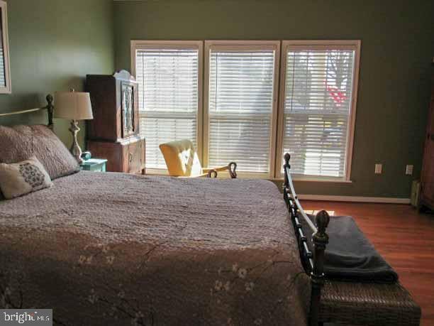 bedroom featuring baseboards and wood finished floors