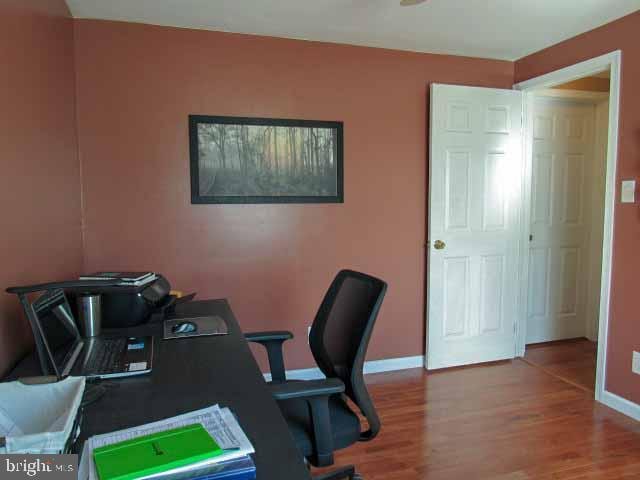 office space with baseboards and wood finished floors