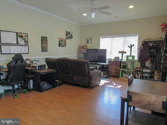 office space featuring a ceiling fan, recessed lighting, wood finished floors, and ornamental molding