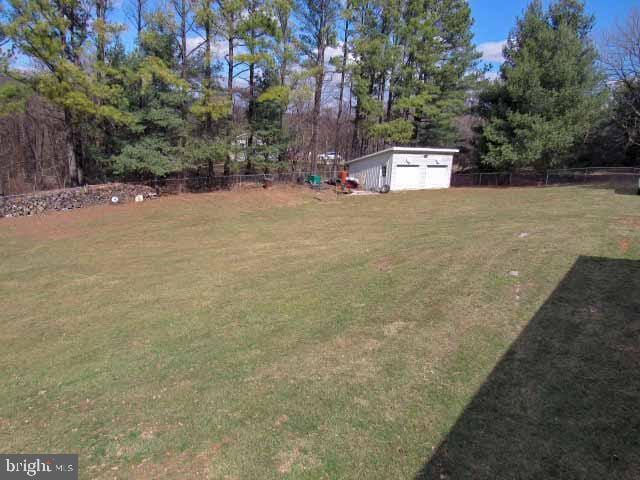 view of yard featuring an outbuilding and fence