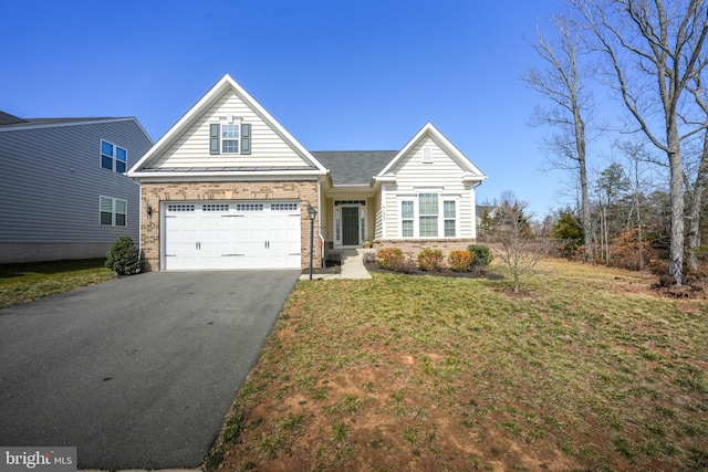 view of front facade featuring brick siding, a front lawn, aphalt driveway, a garage, and a standing seam roof