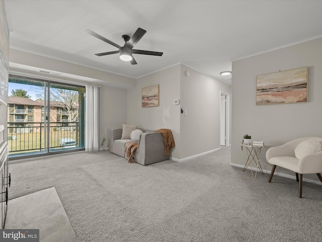 living area featuring a ceiling fan, baseboards, carpet, and crown molding