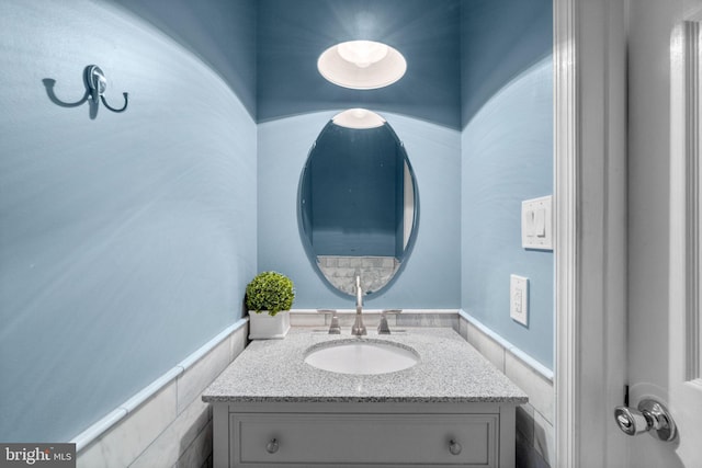 bathroom with a wainscoted wall and vanity