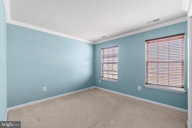 carpeted spare room featuring visible vents, baseboards, and ornamental molding