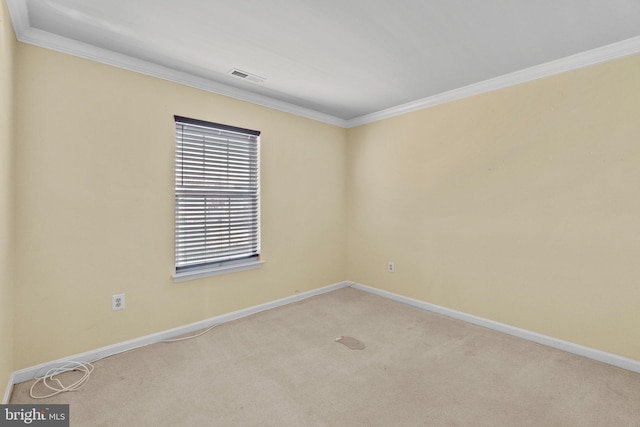 carpeted empty room with visible vents, crown molding, and baseboards