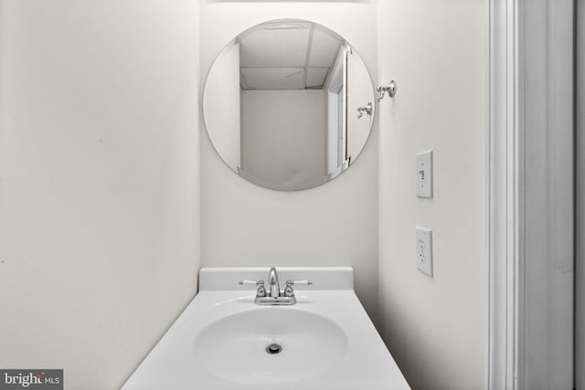 bathroom with a paneled ceiling and a sink