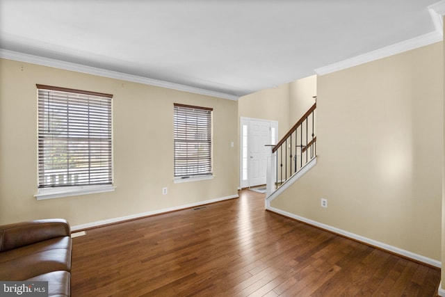 unfurnished living room with stairs, crown molding, baseboards, and wood-type flooring