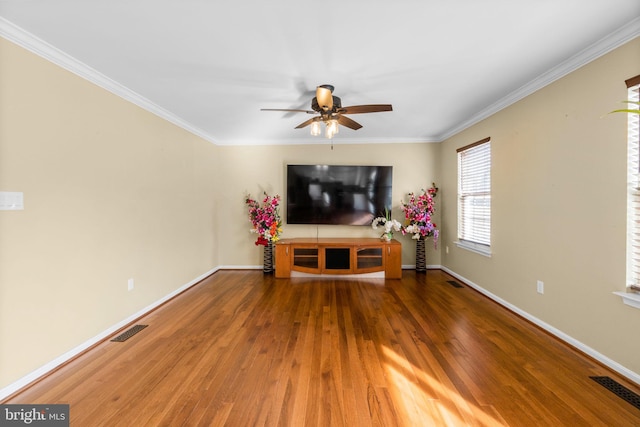 living room featuring crown molding, wood finished floors, visible vents, and baseboards